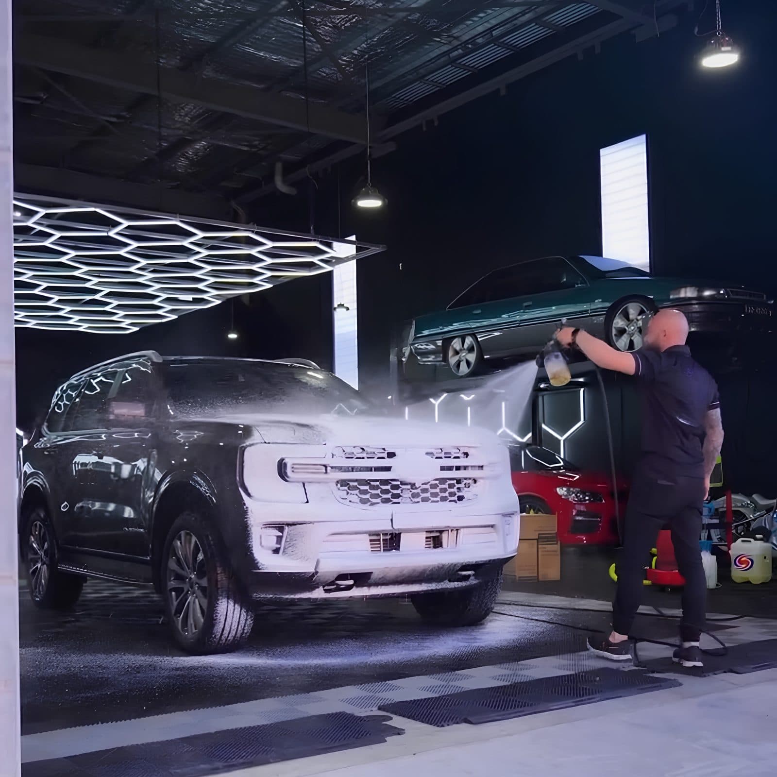 SUV covered in snow foam during a maintenance wash